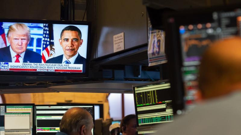 Images of President Trump and former President Barack Obama are on television as traders work on the floor of the New York Stock Exchange. Images of President Trump and former President Barack Obama are on television as traders work on the floor of the New York Stock Exchange.