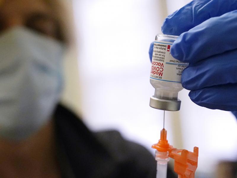 A booster dose of the Moderna COVID-19 vaccine is prepared during a vaccination clinic on Dec. 29 in Lawrence, Mass. The FDA is now shortening the wait time between the second dose and the booster to five months from six months. A booster dose of the Moderna COVID-19 vaccine is prepared during a vaccination clinic on Dec. 29 in Lawrence, Mass. The FDA is now shortening the wait time between the second dose and the booster to five months from six months.