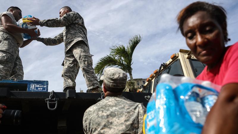 U.S. Army soldiers pass out water, provided by FEMA, to residents in a neighborhood without grid electricity or running water in San Isidro, Puerto Rico, on Oct. 17, 2017. U.S. Army soldiers pass out water, provided by FEMA, to residents in a neighborhood without grid electricity or running water in San Isidro, Puerto Rico, on Oct. 17, 2017.