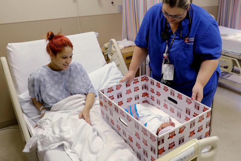 Keyshla Rivera smiles at her newborn son Jesus as registered nurse Christine Weick demonstrates a baby box before her discharge from Temple University Hospital in Philadelphia in 2016. All mothers who deliver at the hospital receive a box, which functions Keyshla Rivera smiles at her newborn son Jesus as registered nurse Christine Weick demonstrates a baby box before her discharge from Temple University Hospital in Philadelphia in 2016. All mothers who deliver at the hospital receive a box, which functions