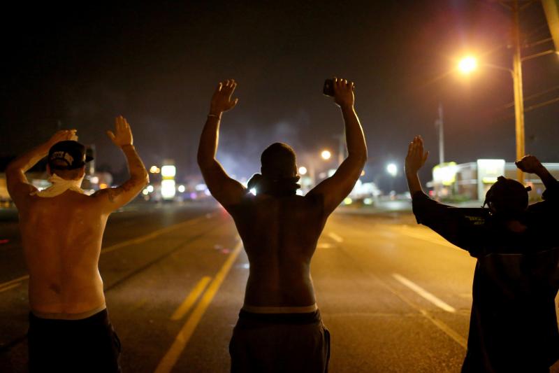 Demonstrators raise their arms and chant "Hands up, don't shoot" on Aug. 17, 2014, as they protest the shooting death of Michael Brown in Ferguson, Mo. Demonstrators raise their arms and chant "Hands up, don't shoot" on Aug. 17, 2014, as they protest the shooting death of Michael Brown in Ferguson, Mo.