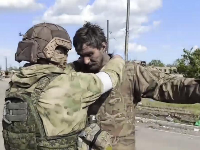 In this still taken from video released by the Russian Defense Ministry on May 20, 2022, a Russian serviceman frisks a Ukrainian soldier leaving the besieged Azovstal steel plant in Mariupol. In this still taken from video released by the Russian Defense Ministry on May 20, 2022, a Russian serviceman frisks a Ukrainian soldier leaving the besieged Azovstal steel plant in Mariupol.