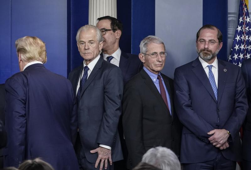 White House economic adviser Peter Navarro (center, left) and Dr. Anthony Fauci, director of the National Institute of Allergy and Infectious Diseases, stand back to back after a White House Coronavirus Task Force briefing on March 9. Navarro wrote an opi White House economic adviser Peter Navarro (center, left) and Dr. Anthony Fauci, director of the National Institute of Allergy and Infectious Diseases, stand back to back after a White House Coronavirus Task Force briefing on March 9. Navarro wrote an opi