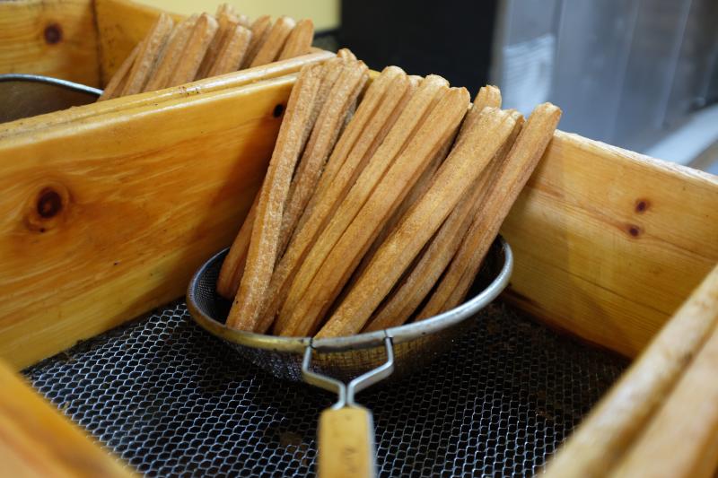 Fresh churros are drained before they are stacked on trays for vendors to pick up. Fresh churros are drained before they are stacked on trays for vendors to pick up.