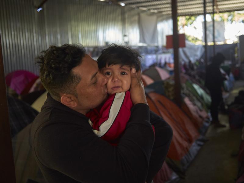 Juan Carlos Perla of El Salvador kisses his 10-month-old son, Joshua, inside a migrant shelter in Tijuana, Mexico, where they await their asylum hearing in San Diego. Juan Carlos Perla of El Salvador kisses his 10-month-old son, Joshua, inside a migrant shelter in Tijuana, Mexico, where they await their asylum hearing in San Diego.