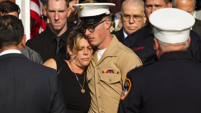 Erika Starke, left, is comforted by her son, Michael Haub, as they attend a second funeral service for New York Fire Department firefighter Michael Haub, in Franklin Square, N.Y. The New York City medical examiner identified more of his remains recovered Erika Starke, left, is comforted by her son, Michael Haub, as they attend a second funeral service for New York Fire Department firefighter Michael Haub, in Franklin Square, N.Y. The New York City medical examiner identified more of his remains recovered
