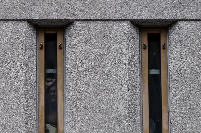 A prisoner looks out of his jail window as protesters gather outside the federal detention center in Miami on June 12, 2020, during a demonstration over the death of George Floyd. A prisoner looks out of his jail window as protesters gather outside the federal detention center in Miami on June 12, 2020, during a demonstration over the death of George Floyd.