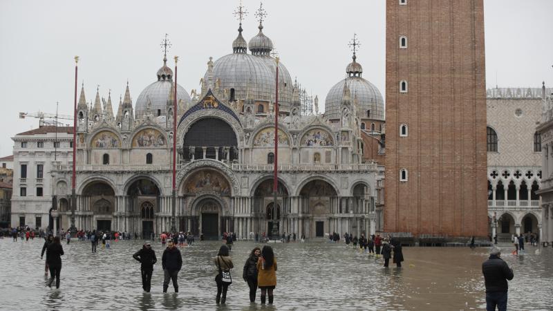 People in front of St. Mark's Basilica wade in flood water in Venice on Wednesday. People in front of St. Mark's Basilica wade in flood water in Venice on Wednesday.