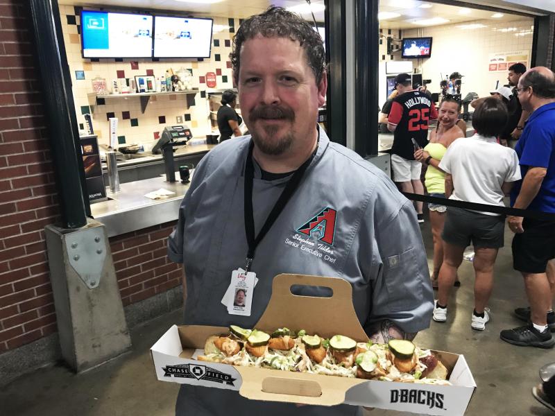 Stephen Tilder, the executive chef at Chase Field in Phoenix, holds the SI Cover Dog, a collaboration with a Sports Illustrated reporter. Stephen Tilder, the executive chef at Chase Field in Phoenix, holds the SI Cover Dog, a collaboration with a Sports Illustrated reporter.