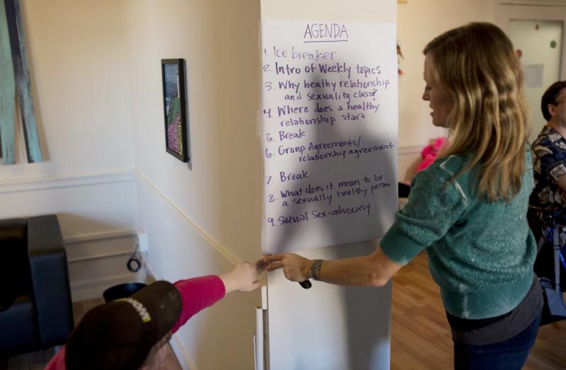 A participant helps Park hang the agenda on the wall at the start of class. A participant helps Park hang the agenda on the wall at the start of class.