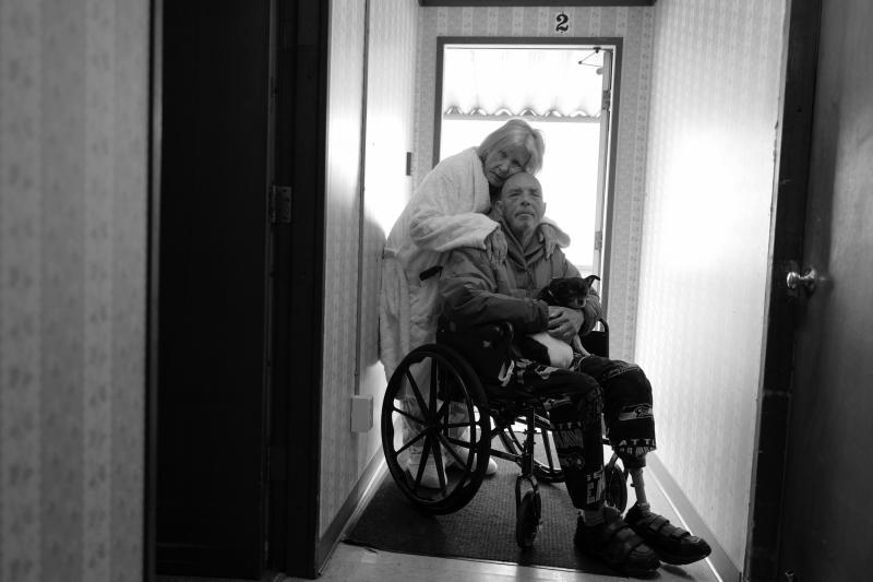 Karen hugs Tony in his wheelchair on April 14, 2022. They now live in Burlington, Wash., and their mobile home no longer exists on the island. They are grateful to be together after being separated for long periods of time during the pandemic. Karen hugs Tony in his wheelchair on April 14, 2022. They now live in Burlington, Wash., and their mobile home no longer exists on the island. They are grateful to be together after being separated for long periods of time during the pandemic.