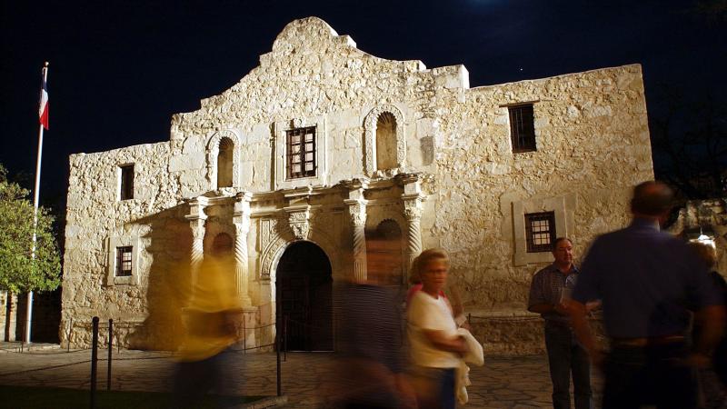 Visitors walk around the outside of the Alamo in San Antonio. Visitors walk around the outside of the Alamo in San Antonio.