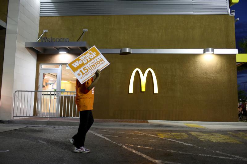 Protesters gather at a McDonald's to ask for higher wages on April 15, 2015 in Miami Gardens, Fla. Food labor advocate Saru Jayaraman writes in a new book that the company has taken the "low road" and lobbied extensively for lower wages and working condit Protesters gather at a McDonald's to ask for higher wages on April 15, 2015 in Miami Gardens, Fla. Food labor advocate Saru Jayaraman writes in a new book that the company has taken the "low road" and lobbied extensively for lower wages and working condit
