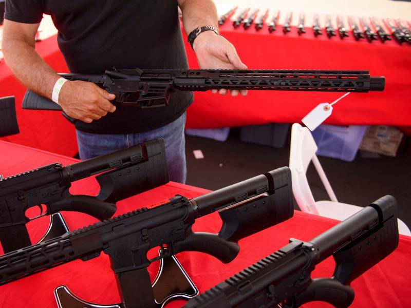 A clerk shows a customer an AR-15 style rifle at a gun show in Costa Mesa, Calif. in June 2021. Gun sales increased in the U.S, following COVID-19 pandemic lockdowns. A clerk shows a customer an AR-15 style rifle at a gun show in Costa Mesa, Calif. in June 2021. Gun sales increased in the U.S, following COVID-19 pandemic lockdowns.