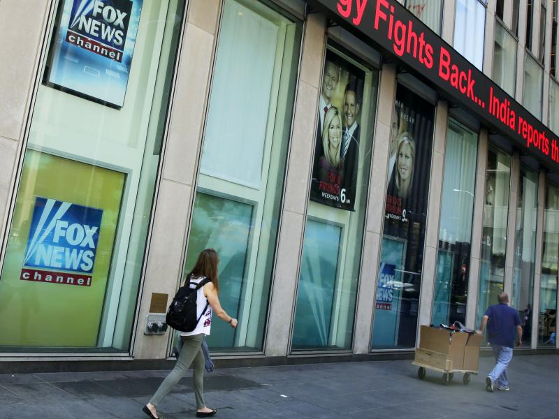 People pass the News Corporation headquarters building and Fox News studios in New York. People pass the News Corporation headquarters building and Fox News studios in New York.