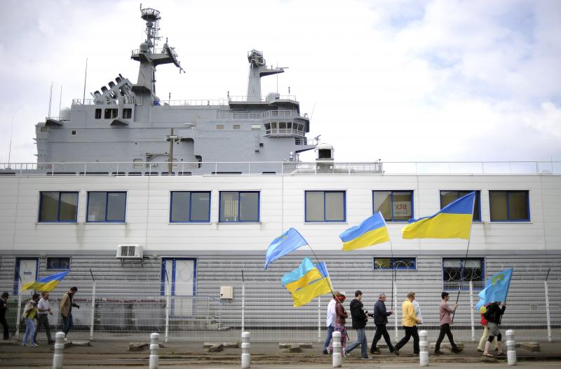 People holding Ukrainian and Crimean Tatar flags demonstrate in front of the French-built Vladivostok warship in St. Nazaire, western France, on June 1. The protesters are opposed to the sale of the Vladivostok and Sevastopol warships to Russia. People holding Ukrainian and Crimean Tatar flags demonstrate in front of the French-built Vladivostok warship in St. Nazaire, western France, on June 1. The protesters are opposed to the sale of the Vladivostok and Sevastopol warships to Russia.