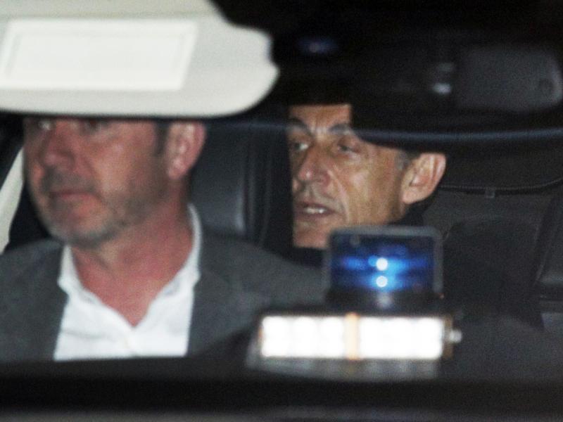 Former French President Nicolas Sarkozy, right, leaves the police station where he was held, in Nanterre, outside Paris, on Wednesday. Former French President Nicolas Sarkozy, right, leaves the police station where he was held, in Nanterre, outside Paris, on Wednesday.