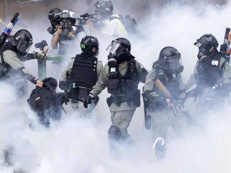 Police in riot gear move through a cloud of smoke as they detain a protester, in November. Freedom House cited the willingness of people in Hong Kong to protest as encouraging. Police in riot gear move through a cloud of smoke as they detain a protester, in November. Freedom House cited the willingness of people in Hong Kong to protest as encouraging.