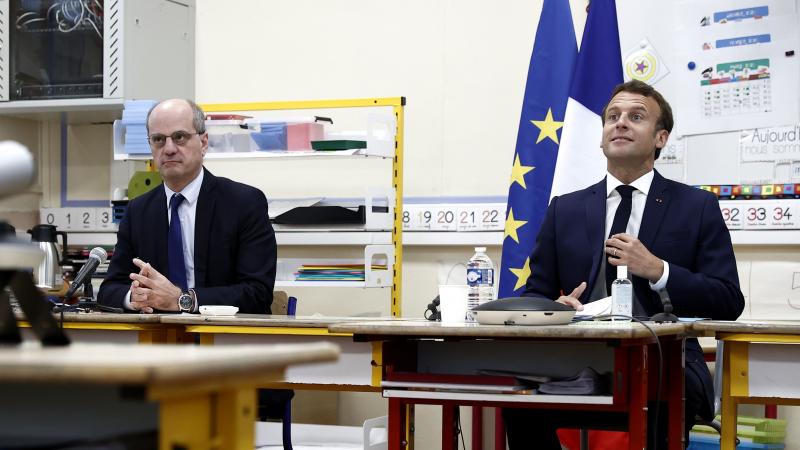 French Education Minister Jean-Michel Blanquer (left) and French President Emmanuel Macron participate in a video conference with mayors and directors of schools at the Pierre Ronsard elementary school in Poissy, west of Paris, on Tuesday. French Education Minister Jean-Michel Blanquer (left) and French President Emmanuel Macron participate in a video conference with mayors and directors of schools at the Pierre Ronsard elementary school in Poissy, west of Paris, on Tuesday.