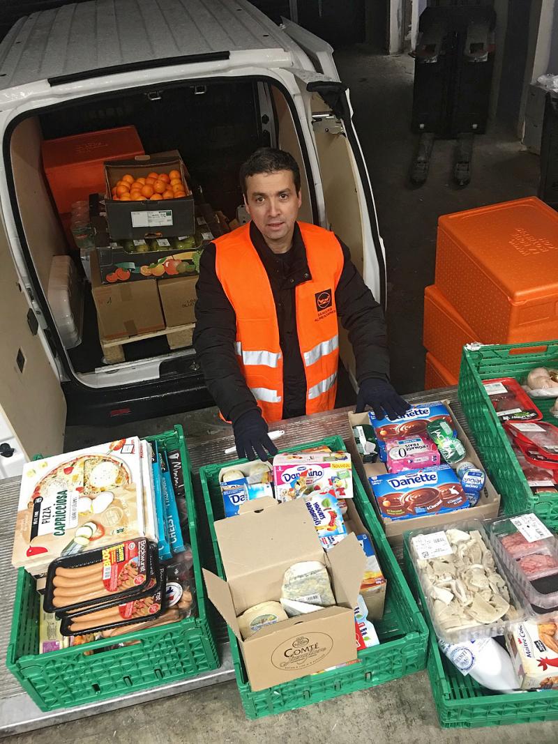 Djerbrani checks food donations from a French grocery store before driving it across town to a church, which will distribute it to poor families. Djerbrani checks food donations from a French grocery store before driving it across town to a church, which will distribute it to poor families.