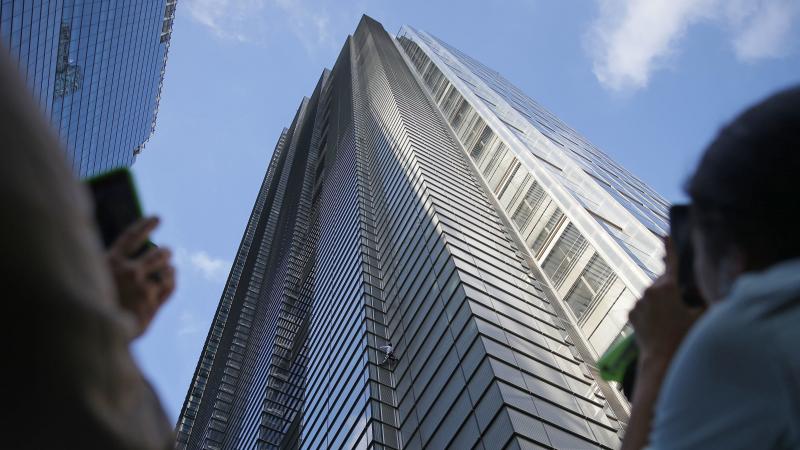 People watch as French urban climber Alain Robert ascends the 46-story Heron Tower in central London on Thursday. People watch as French urban climber Alain Robert ascends the 46-story Heron Tower in central London on Thursday.
