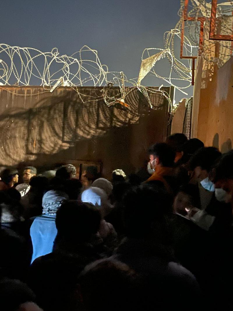 People waiting outside of a gate at the Kabul airport. People waiting outside of a gate at the Kabul airport.
