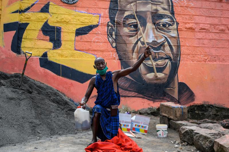 A Maasai man in the Kibera slum of Nairobi, Kenya, prays next to a mural of George Floyd, painted by the artist Allan Mwangi on June 3. A Maasai man in the Kibera slum of Nairobi, Kenya, prays next to a mural of George Floyd, painted by the artist Allan Mwangi on June 3.