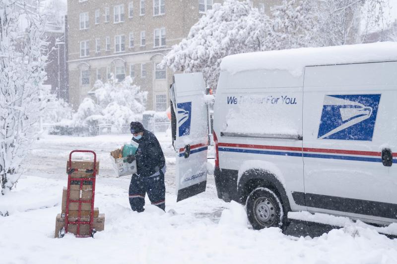 A postal worker carries packages through the snow on Jan. 3 in Washington, D.C. A postal worker carries packages through the snow on Jan. 3 in Washington, D.C.