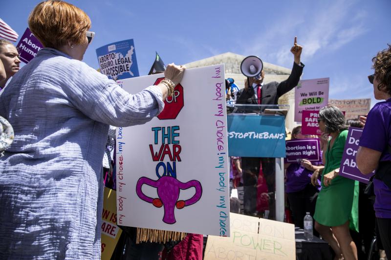 A pro-choice activist holds a sign as Sen. Cory Booker, a Democrat from New Jersey, speaks during a rally in front of the U.S. Supreme Court in May. A recent Gallup poll found that more Americans want less strict abortion laws. A pro-choice activist holds a sign as Sen. Cory Booker, a Democrat from New Jersey, speaks during a rally in front of the U.S. Supreme Court in May. A recent Gallup poll found that more Americans want less strict abortion laws.