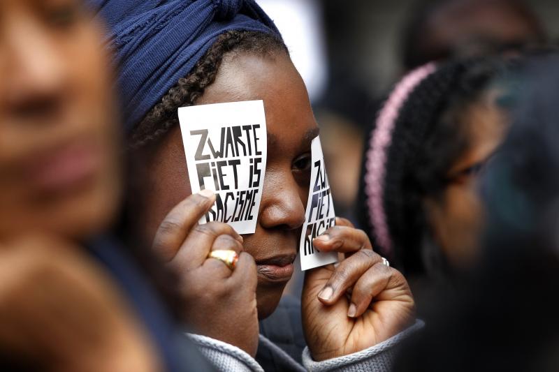 A demonstrator holds a sign reading "Black Pete Is Racism" during a 2013 demonstration in Amsterdam. Zwarte Piet or Black Pete is traditionally depicted by white people wearing blackface, Afro wigs and red lipstick. A demonstrator holds a sign reading "Black Pete Is Racism" during a 2013 demonstration in Amsterdam. Zwarte Piet or Black Pete is traditionally depicted by white people wearing blackface, Afro wigs and red lipstick.