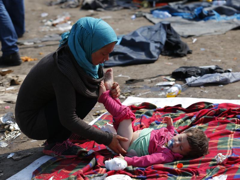 A migrant takes care of her baby at a collection point near the Serbian-Hungarian border in Roszke, Hungary, on Saturday. A migrant takes care of her baby at a collection point near the Serbian-Hungarian border in Roszke, Hungary, on Saturday.