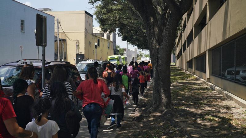 Women and children walk to a bus in McAllen, Texas. People released from immigration detention centers are often dropped off at the McAllen bus station in the Rio Grande Valley. Women and children walk to a bus in McAllen, Texas. People released from immigration detention centers are often dropped off at the McAllen bus station in the Rio Grande Valley.