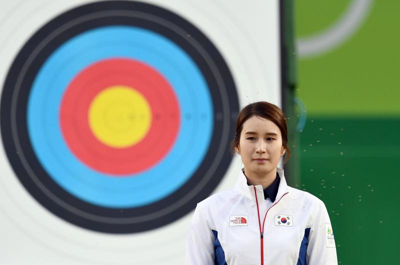 Mosquitoes hover around South Korea's bronze medalist Ki Bo Bae during the medal ceremony for archery, held on Aug. 11 at the Rio Games. Mosquitoes hover around South Korea's bronze medalist Ki Bo Bae during the medal ceremony for archery, held on Aug. 11 at the Rio Games.