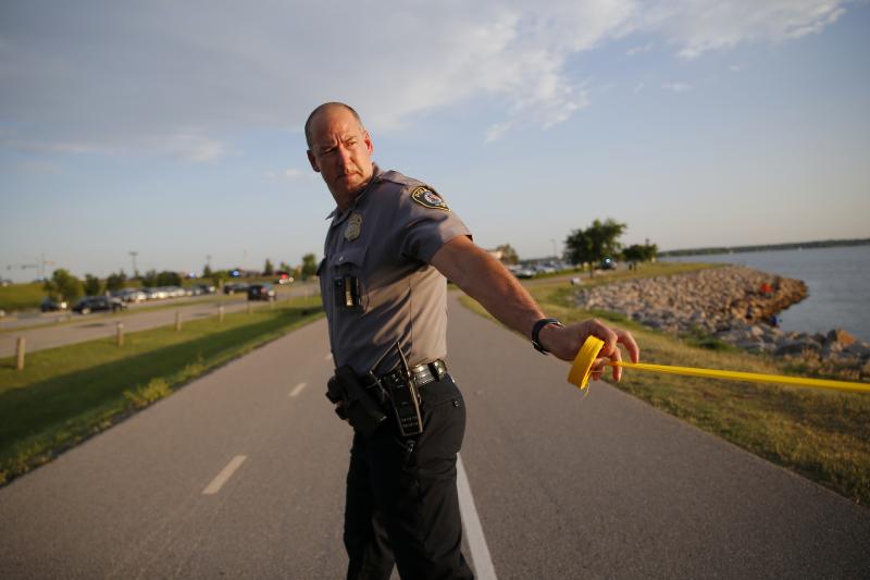 A policeman puts up crime scene tape around the scene of a shooting on the east side of Lake Hefner in Oklahoma City, Okla on Thursday. Police say an armed gunman injured three people at a restaurant before being shot dead by two armed civilians outside. A policeman puts up crime scene tape around the scene of a shooting on the east side of Lake Hefner in Oklahoma City, Okla on Thursday. Police say an armed gunman injured three people at a restaurant before being shot dead by two armed civilians outside.