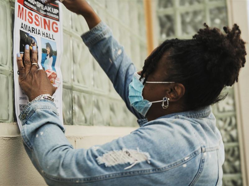 A community member posts flyers for Amaria Hall. A community member posts flyers for Amaria Hall.