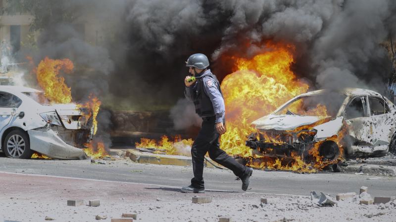 An Israeli firefighter walks next to cars hit by a rocket fired from Gaza on Tuesday in the southern Israeli city of Ashkelon. An Israeli firefighter walks next to cars hit by a rocket fired from Gaza on Tuesday in the southern Israeli city of Ashkelon.