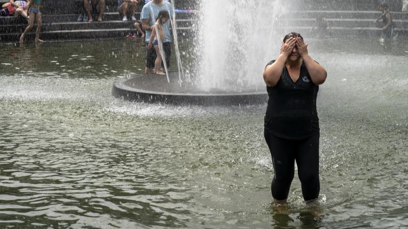 A woman cools off in the fountain at Washington Square Park in New York. Temperatures at or close to 100 degrees are expected in the city this weekend. A woman cools off in the fountain at Washington Square Park in New York. Temperatures at or close to 100 degrees are expected in the city this weekend.