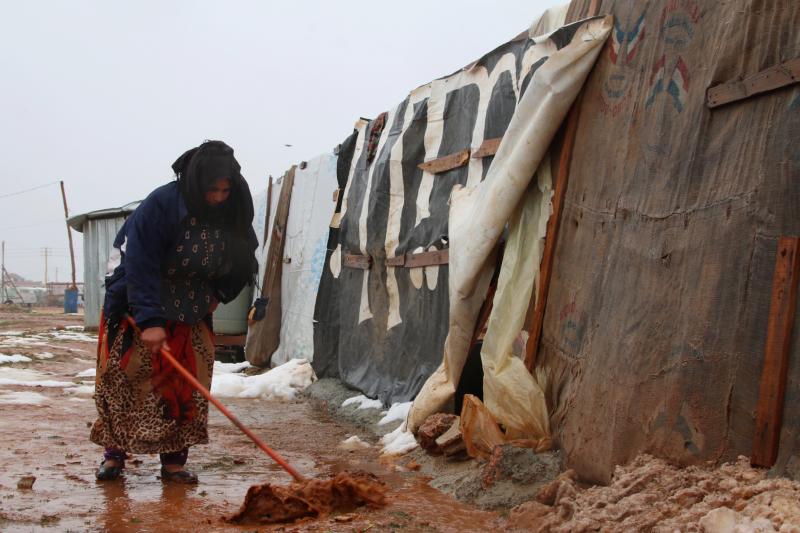 A Syrian refugee shovels mud in front of a makeshift shelter in an unofficial camp for Syrian refugees in Iaat in Lebanon's Bekaa Valley on Tuesday. A Syrian refugee shovels mud in front of a makeshift shelter in an unofficial camp for Syrian refugees in Iaat in Lebanon's Bekaa Valley on Tuesday.