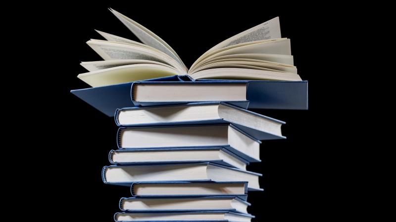 A stack of books on a black background. A stack of books on a black background.