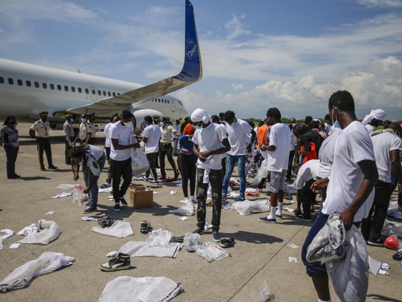 Haitians deported from the U.S. recover their belongings scattered on the tarmac of the Toussaint Louverture International Airport on Tuesday in Port-au-Prince, Haiti. Haitians deported from the U.S. recover their belongings scattered on the tarmac of the Toussaint Louverture International Airport on Tuesday in Port-au-Prince, Haiti.