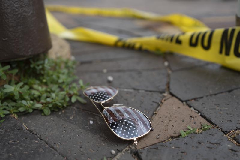 Police crime tape is seen near an American flag-themed sunglasses at the scene of the Fourth of July parade shooting in Highland Park, Ill. Police crime tape is seen near an American flag-themed sunglasses at the scene of the Fourth of July parade shooting in Highland Park, Ill.