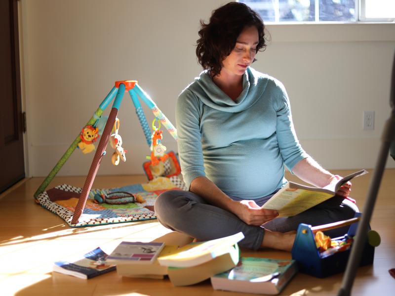Lesley McClurg sits on the floor of her home in Oakland, Calif., reading a birthing book. McClurg has been taking the time to decide between having a home birth or a hospital birth. Lesley McClurg sits on the floor of her home in Oakland, Calif., reading a birthing book. McClurg has been taking the time to decide between having a home birth or a hospital birth.