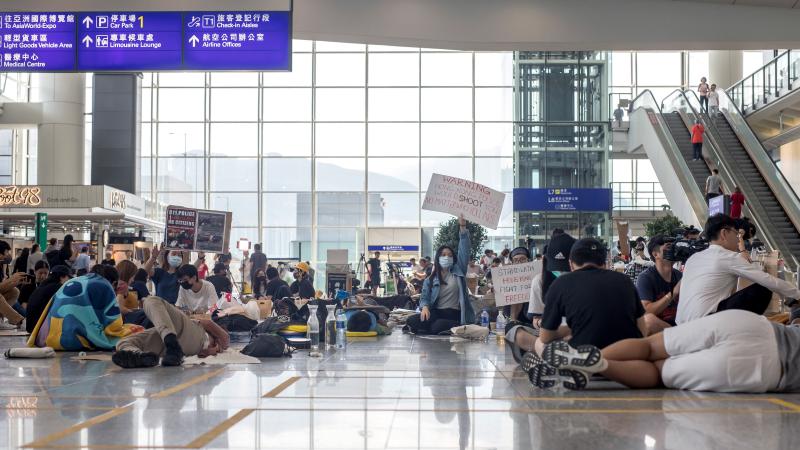 Demonstrators sit and lie on the arrival hall floor at Hong Kong International Airport on Wednesday. Demonstrators sit and lie on the arrival hall floor at Hong Kong International Airport on Wednesday.