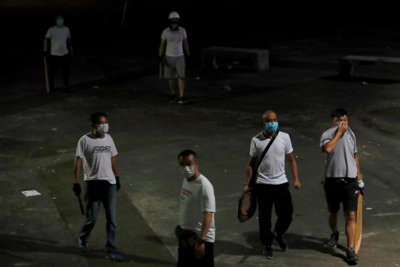 Men in white T-shirts with poles are seen in Yuen Long after clashing with anti-extradition bill demonstrators at a train station in Hong Kong. Men in white T-shirts with poles are seen in Yuen Long after clashing with anti-extradition bill demonstrators at a train station in Hong Kong.