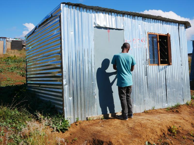 Ayanda stands in the doorway of a shack that he put up on illegally on privately owned farmland in Stellenbosch wine country. He says he grew tired of waiting for housing while living in Kayamandi township. Ayanda stands in the doorway of a shack that he put up on illegally on privately owned farmland in Stellenbosch wine country. He says he grew tired of waiting for housing while living in Kayamandi township.