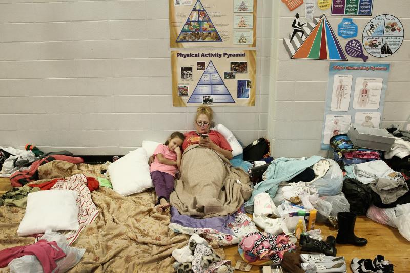 Christine Garcia relaxes with her 8-year-old daughter Mia in the Channelview High School gym. It's been turned into an evacuation shelter for victims of flooding from Harvey. Christine Garcia relaxes with her 8-year-old daughter Mia in the Channelview High School gym. It's been turned into an evacuation shelter for victims of flooding from Harvey.