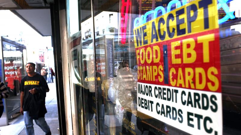 A sign in the window of a New York City market advertises the acceptance of food stamps. A sign in the window of a New York City market advertises the acceptance of food stamps.