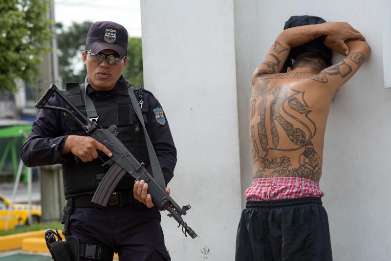 A policeman detains a suspected member of the MS-13 gang at a checkpoint in San Salvador during a ban on public transport imposed by the gangs. A policeman detains a suspected member of the MS-13 gang at a checkpoint in San Salvador during a ban on public transport imposed by the gangs.