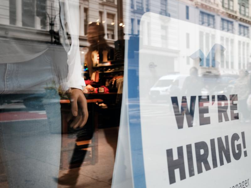 People walk by a hiring sign in a store window in New York on Nov. 17. People walk by a hiring sign in a store window in New York on Nov. 17.