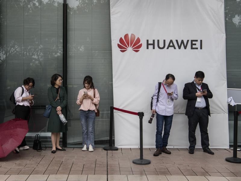 Huawei employees wait for a shuttle bus at the company's campus on April 12 in Shenzhen, China. A senior Huawei official says Google is talking with the U.S. government on behalf of the Chinese telecom giant. Huawei employees wait for a shuttle bus at the company's campus on April 12 in Shenzhen, China. A senior Huawei official says Google is talking with the U.S. government on behalf of the Chinese telecom giant.
